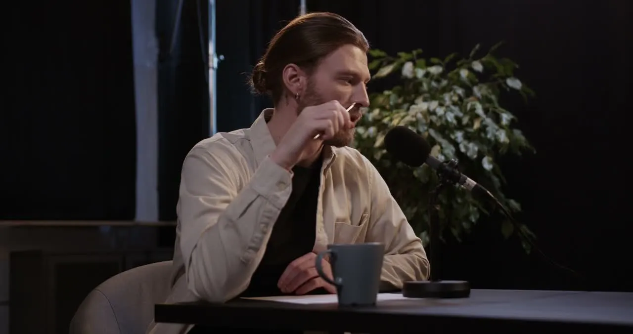 A host mid-thought at a studio microphone.